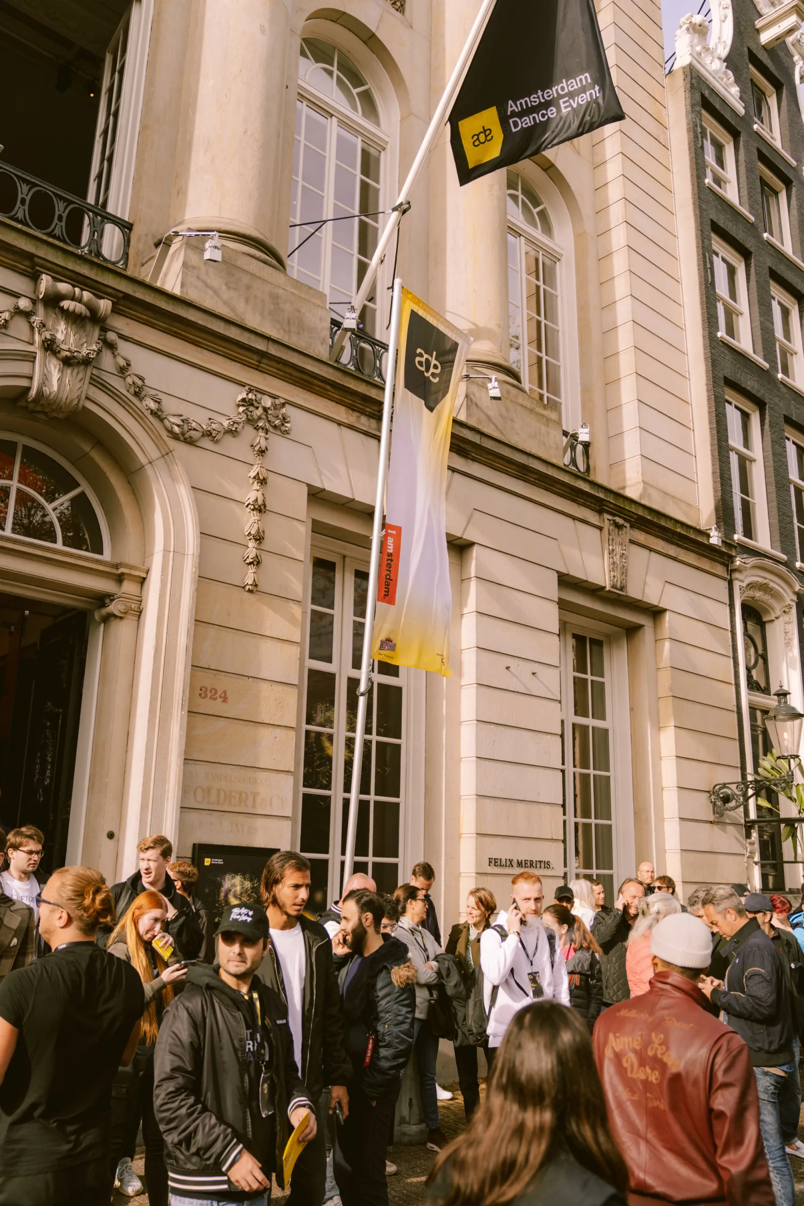 People in conversation at the Felix Meritis entrance during ADE